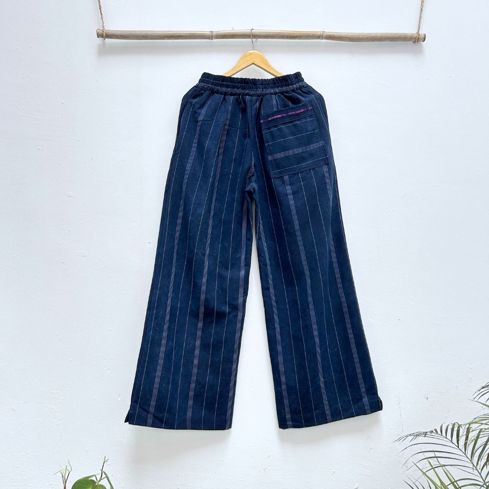 Blue striped pants hanging on a wooden hanger against a white background