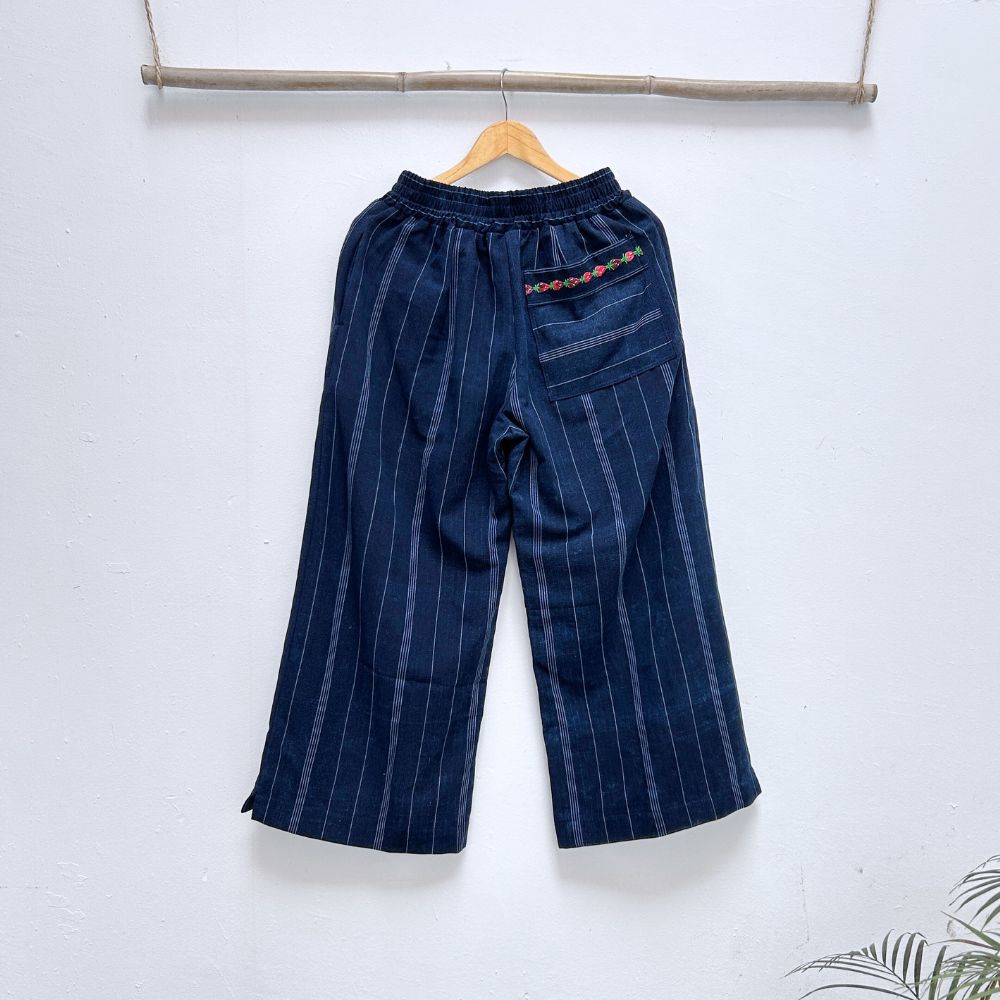Navy blue pinstripe trousers with strawberries randa embroidery  back pocket  on a hanger against a white background