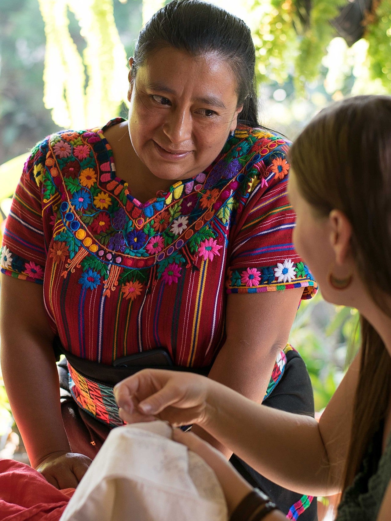 A photo depicting a woman engaging in embroidery work, which represents the craft and cultural experience offered by the Sumpango Embroidery Week course.