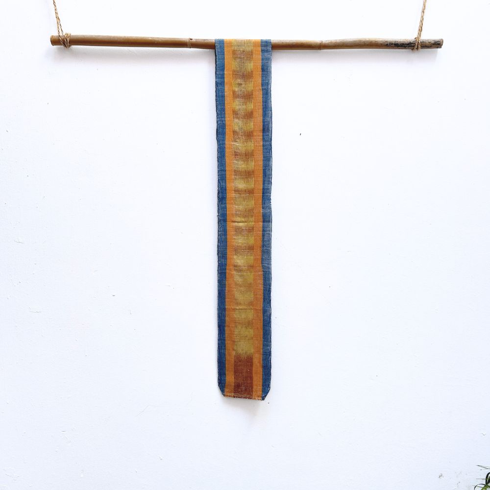 Striped fabric hanging on a stick against a white background
