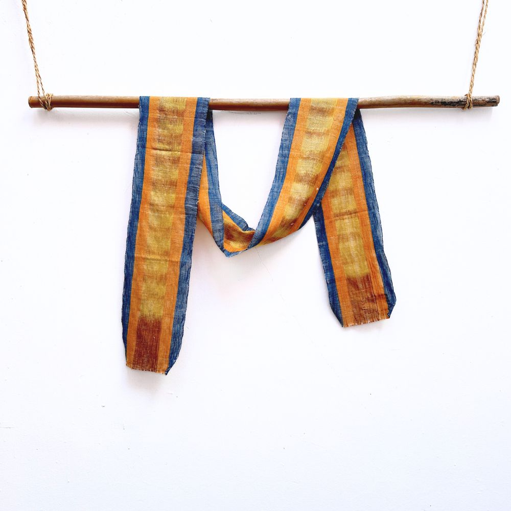 Striped fabric hanging on a stick against a white background