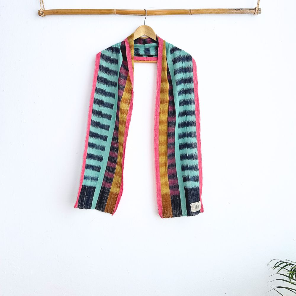 Colorful striped scarf hanging on a wooden hanger against a white background