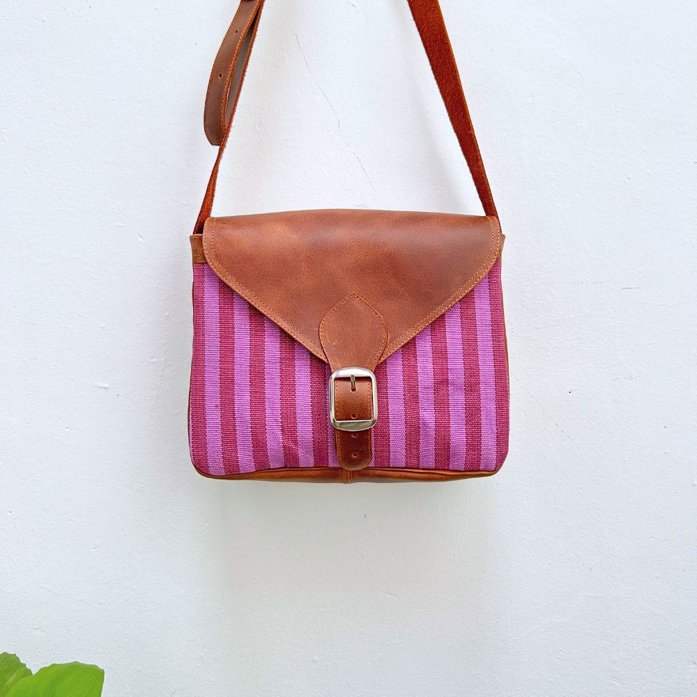 Pink striped bag with brown leather accents on a white background