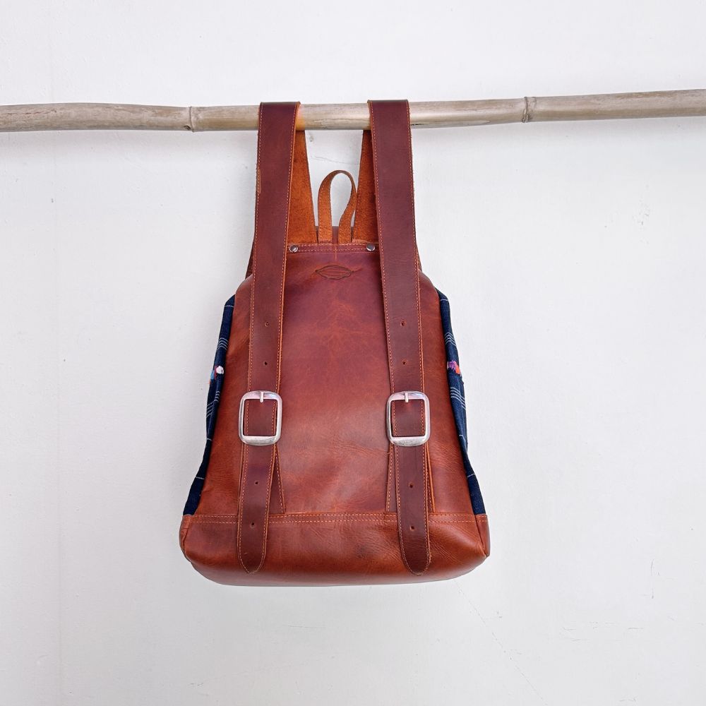 Brown leather backpack with plaid pattern on a white background