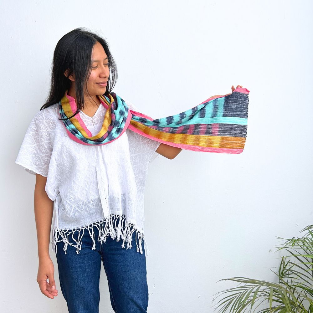 Woman holding a colorful scarf against a white background