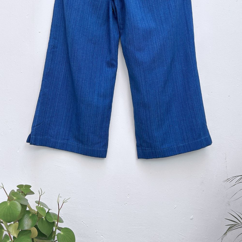 Blue pants on a white background with green plants at the corners