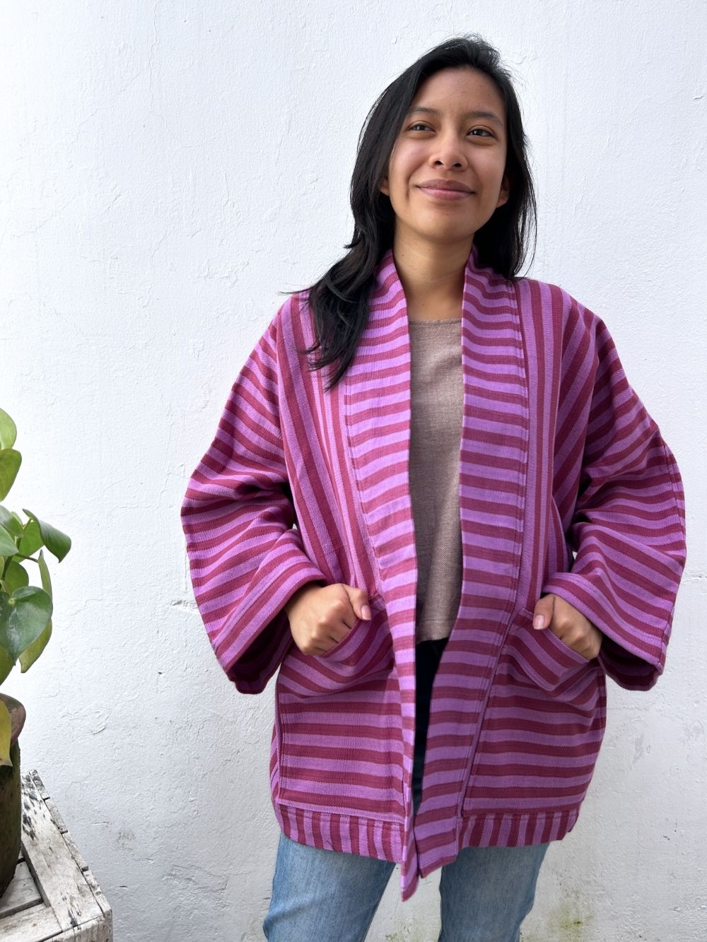 Woman wearing a purple striped jacket against a white background