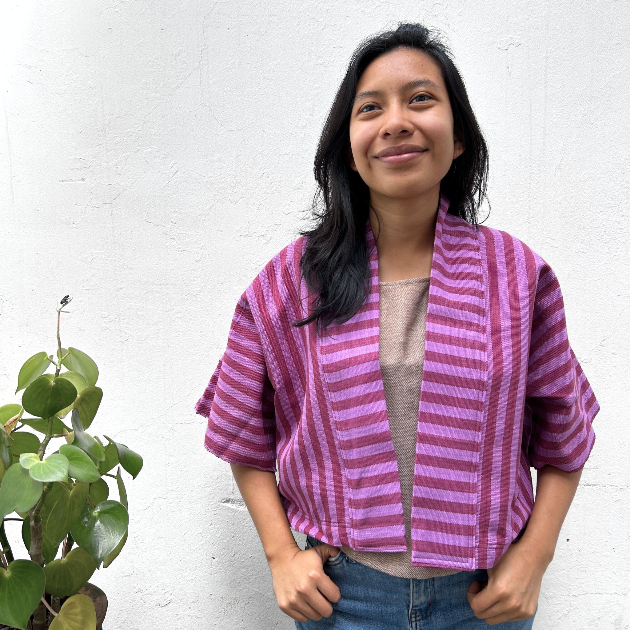 Model  wearing Two Shades of pink striped cropped jacket on a white background.