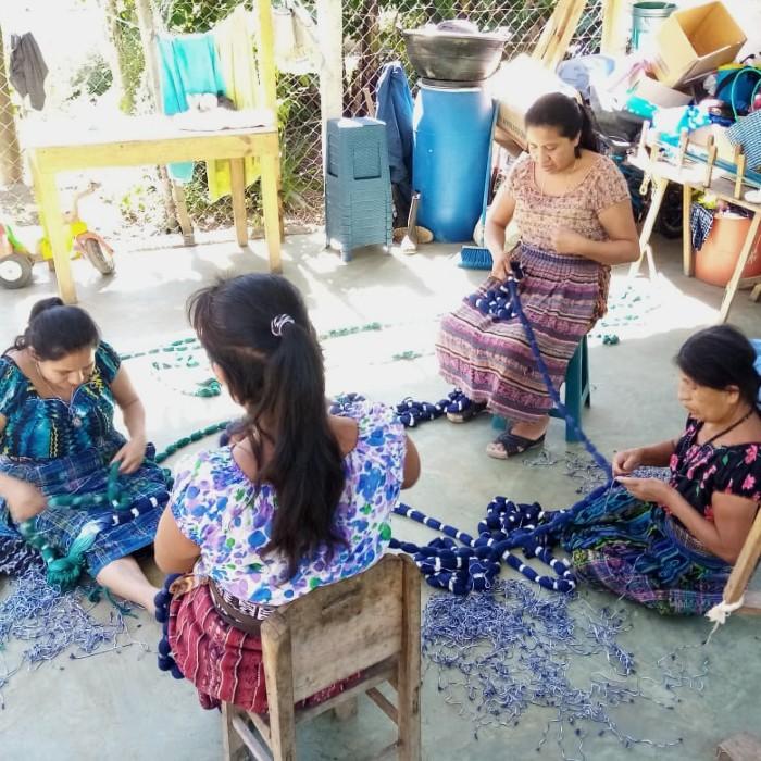 Women preparing warp threads, unraveling ikat knots after dyeing
