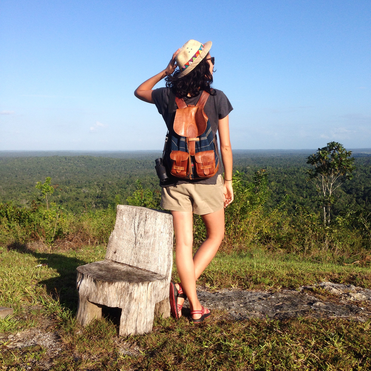 Model wearing a white dress and a leather and fabric back pack
