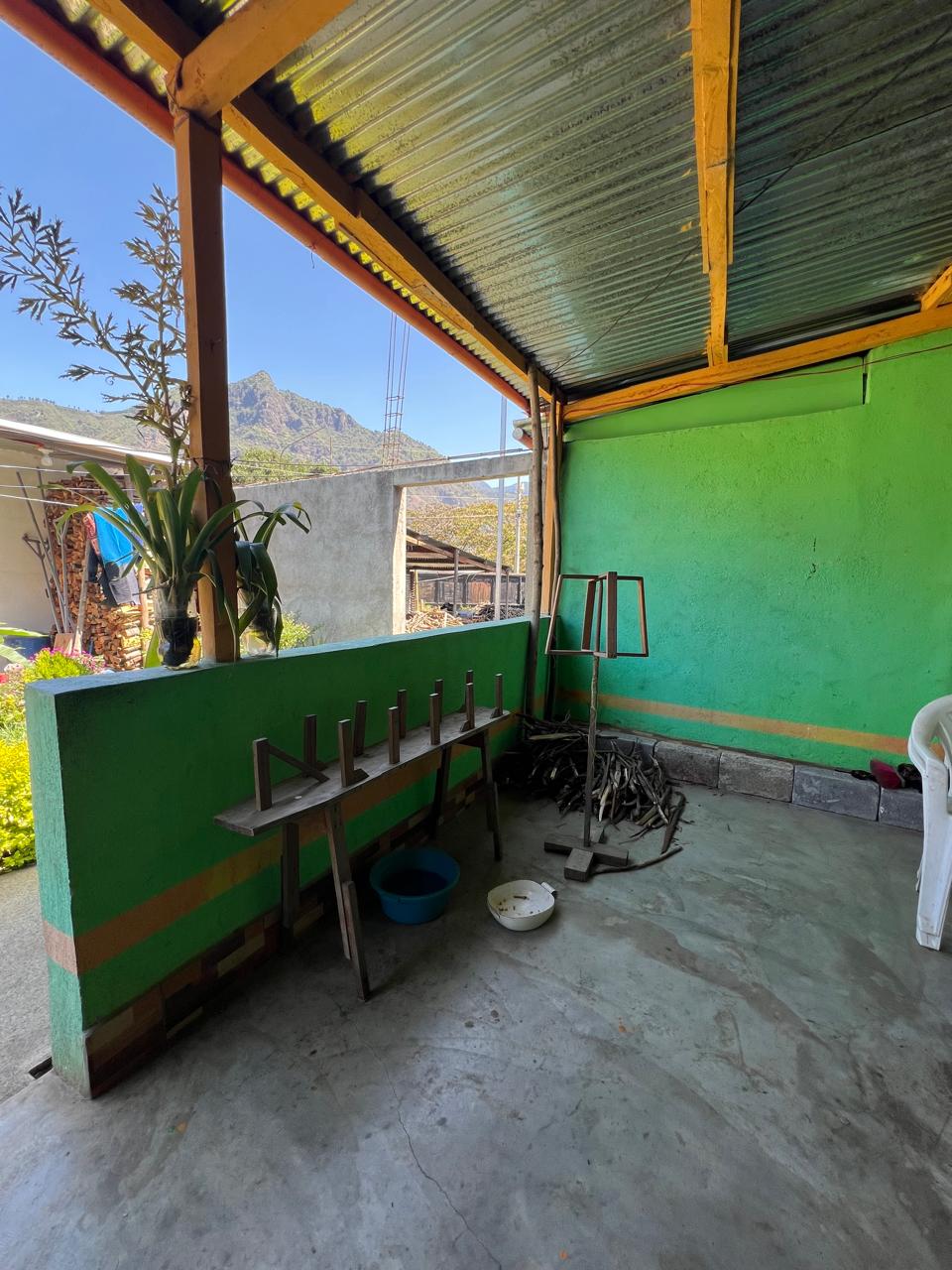 A wooden warping board and other weaving tools on the patio of the home.