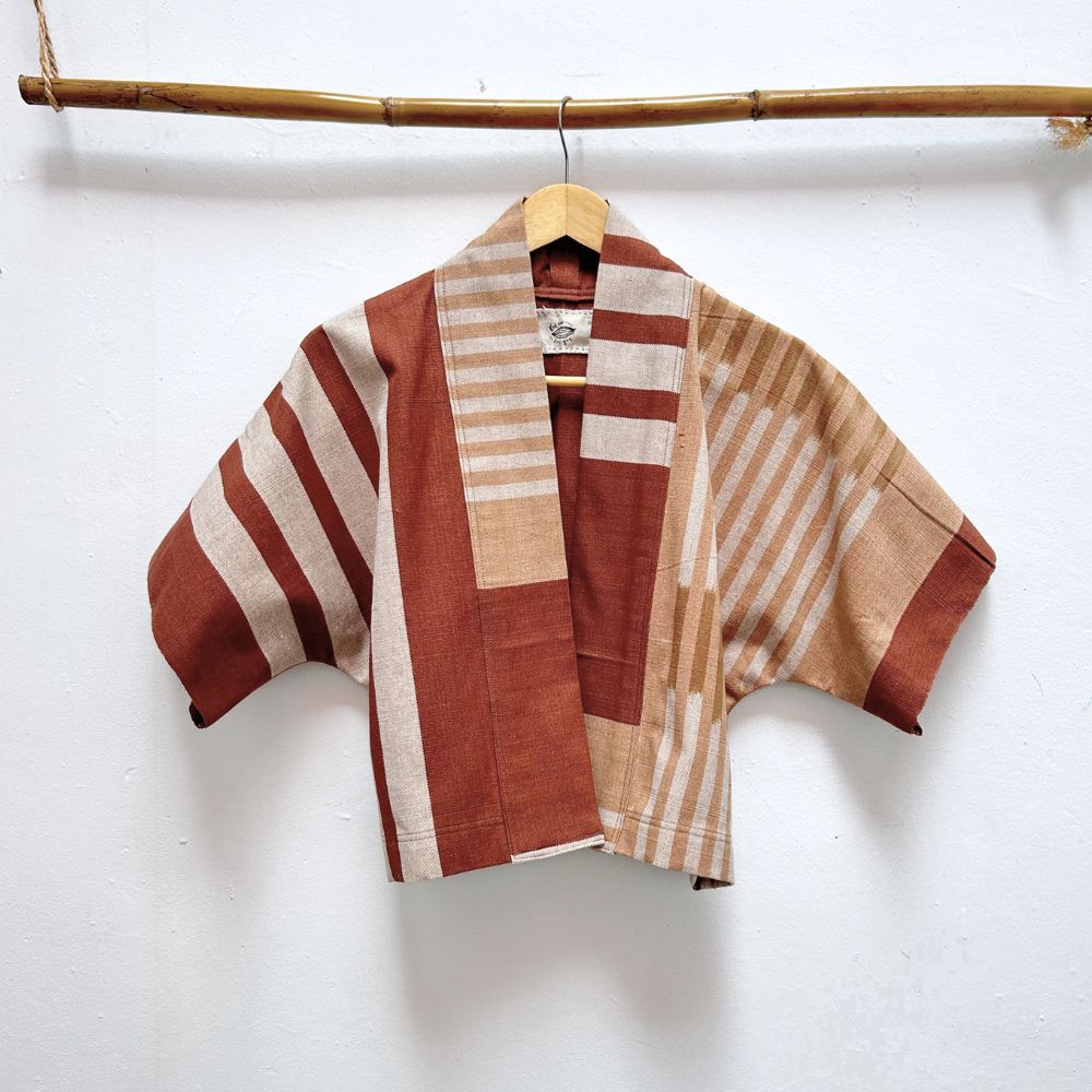 Striped jacket with brown and beige pattern on a hanger against a white background