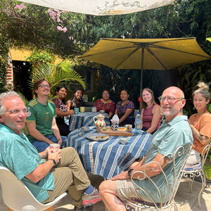 Six students enjoying tea time with their weaving teachers from San Antonio Xenacoj after a weaving session.