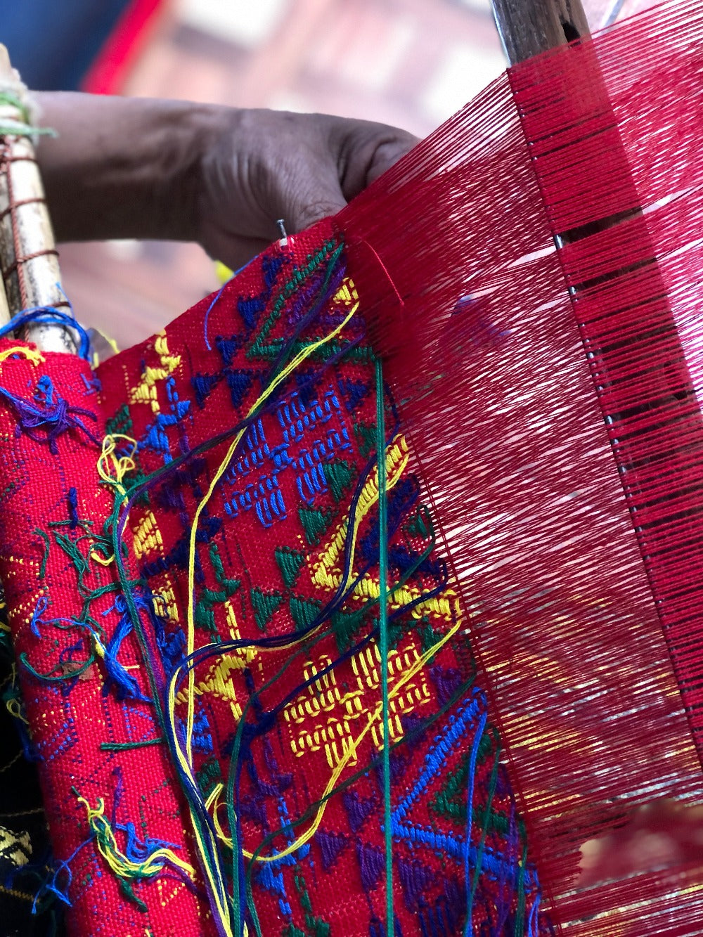 A detailed view of colorful brocade on a backstrap loom.