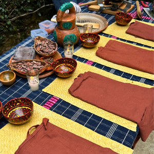 A workshop table set with placemats and aprons prepared for each participant.