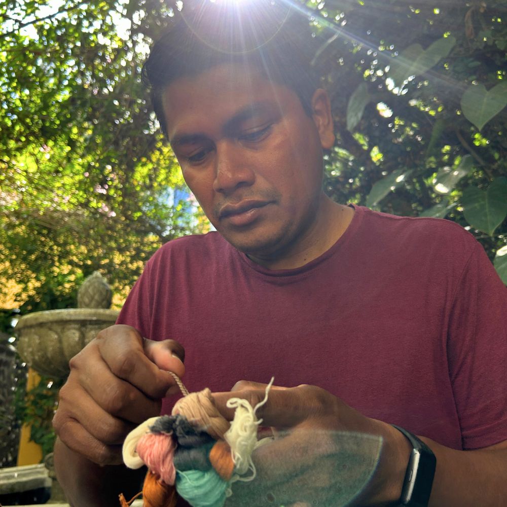 Our teacher Chato explaining the pompom-making process.