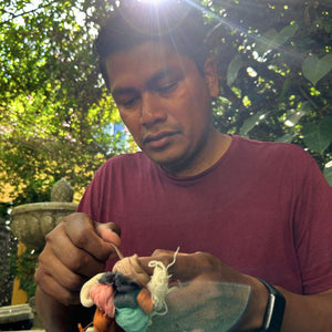Our teacher Chato explaining the pompom-making process.