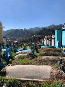 A view of the colorful Chichicastenango cemetery, with lush forest in the back