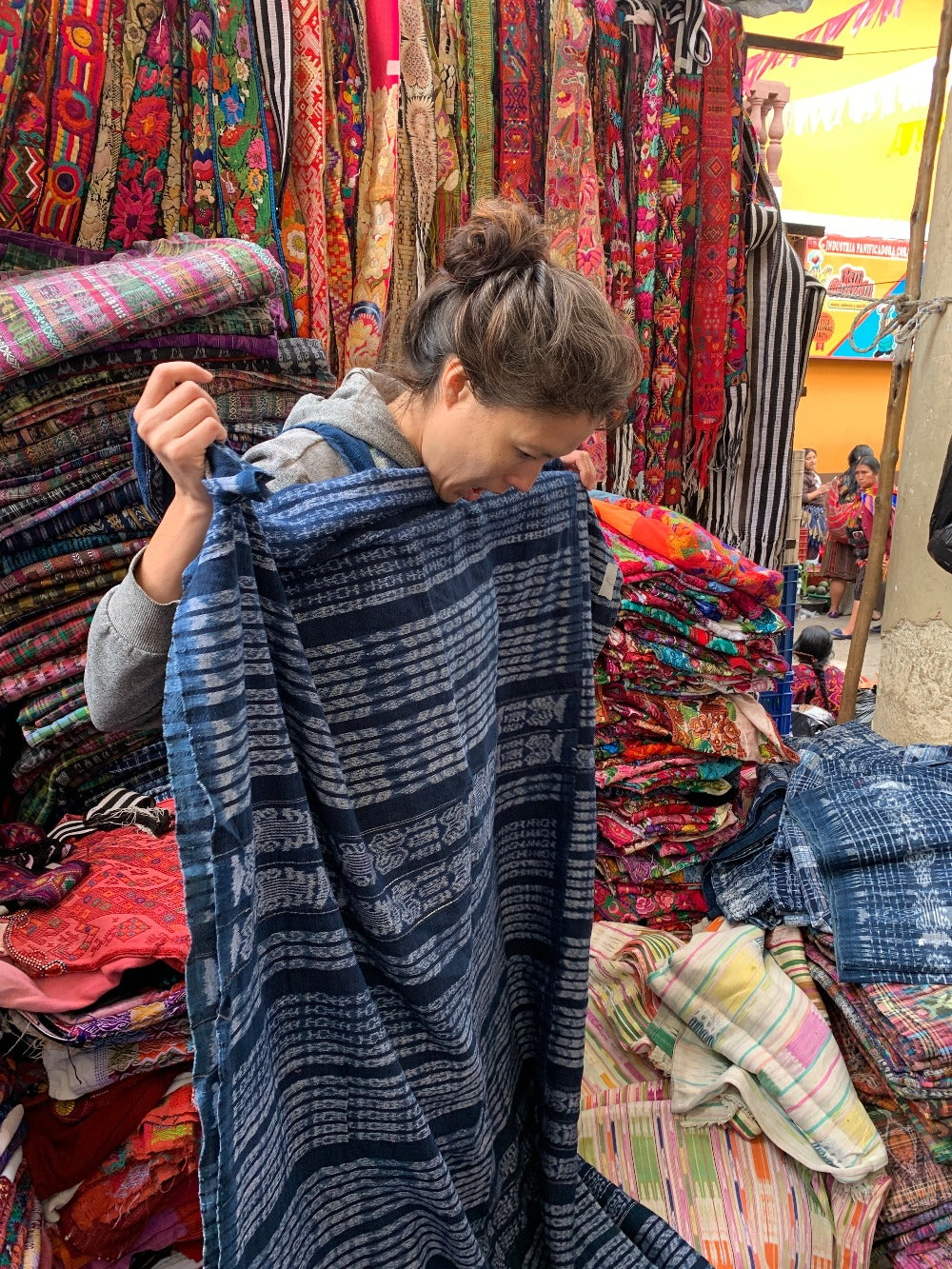 A woman looks at an ikat-filled traditional corte at the Chichicastenango market