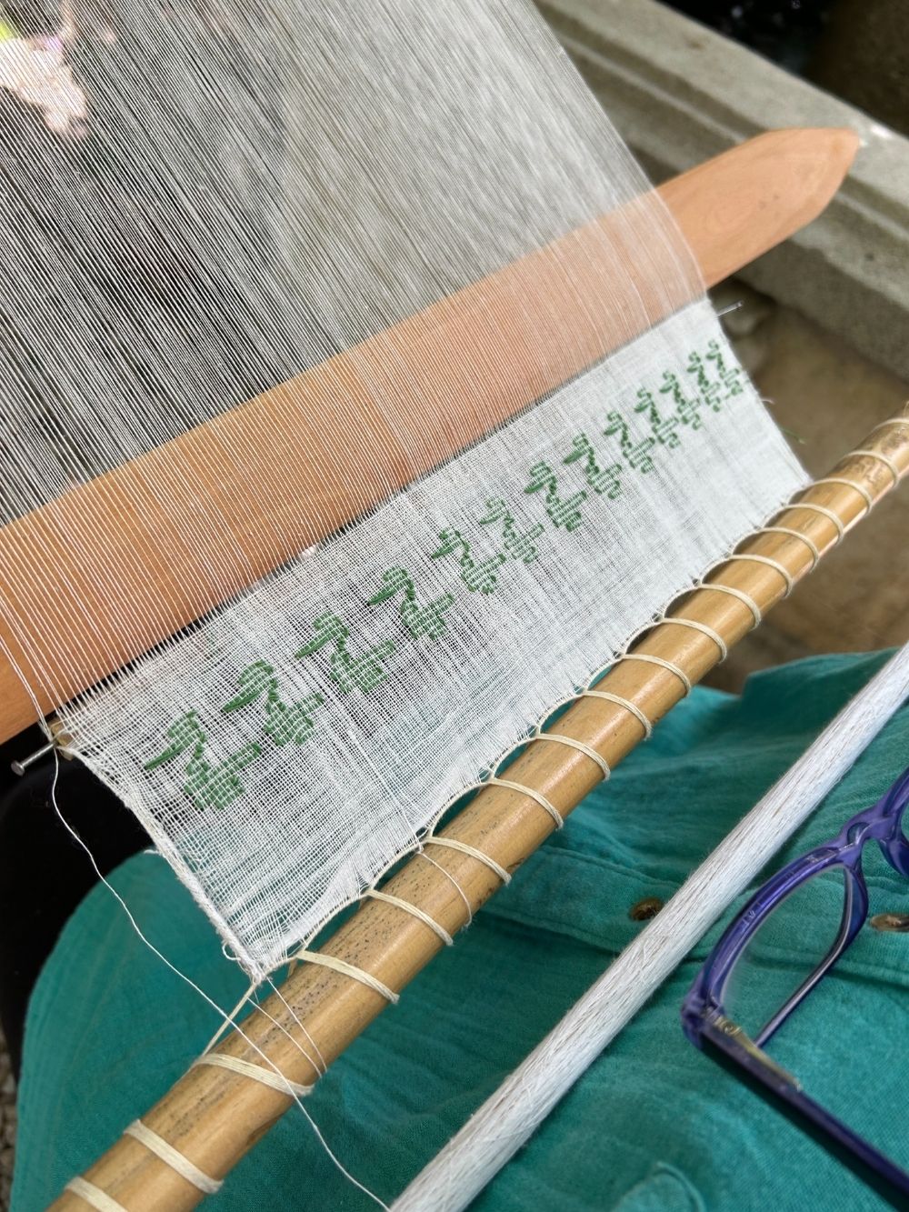 Weaving loom with green pattern brocade