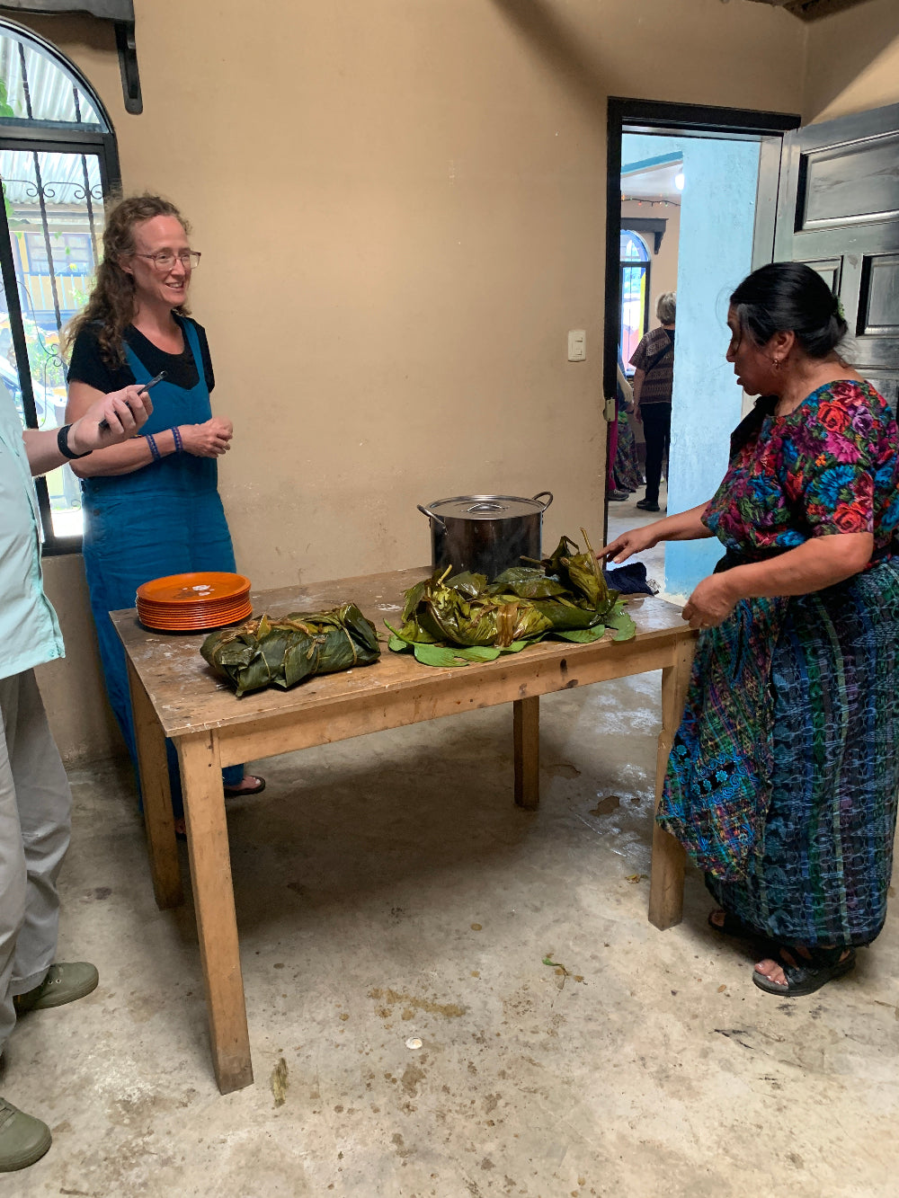 Participants preparing a traditional dish wrapped in a large leaf.