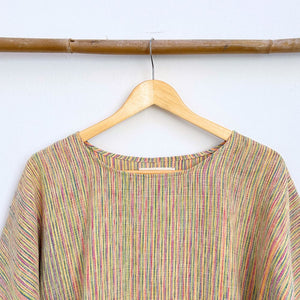 Multicolored striped shirt on a wooden hanger against a white background
