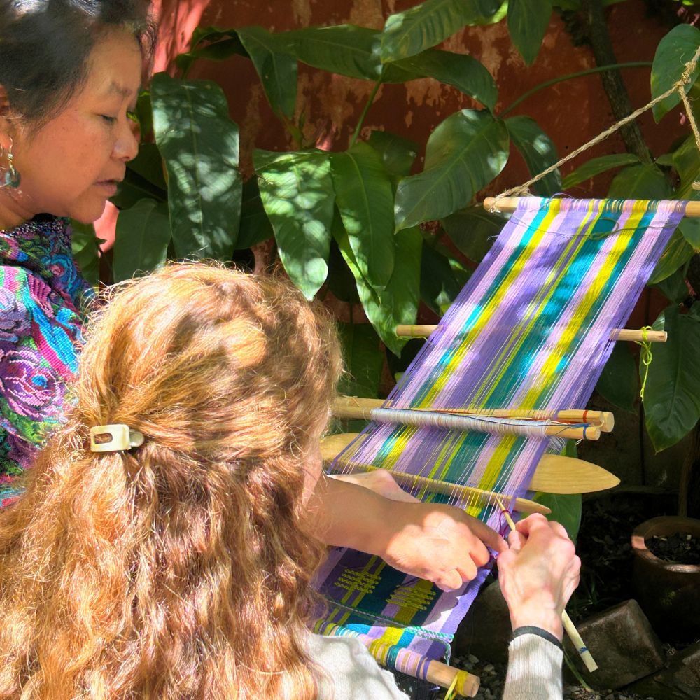 Teacher showing the student how to create figures and patterns on her loom.