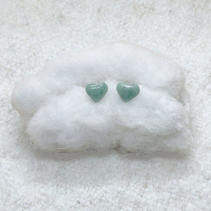 Heart-Shaped Light Green Jade Stud Earrings on a white cotton surface