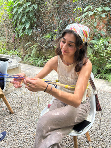 Woman sitting outdoors surrounded by greenery