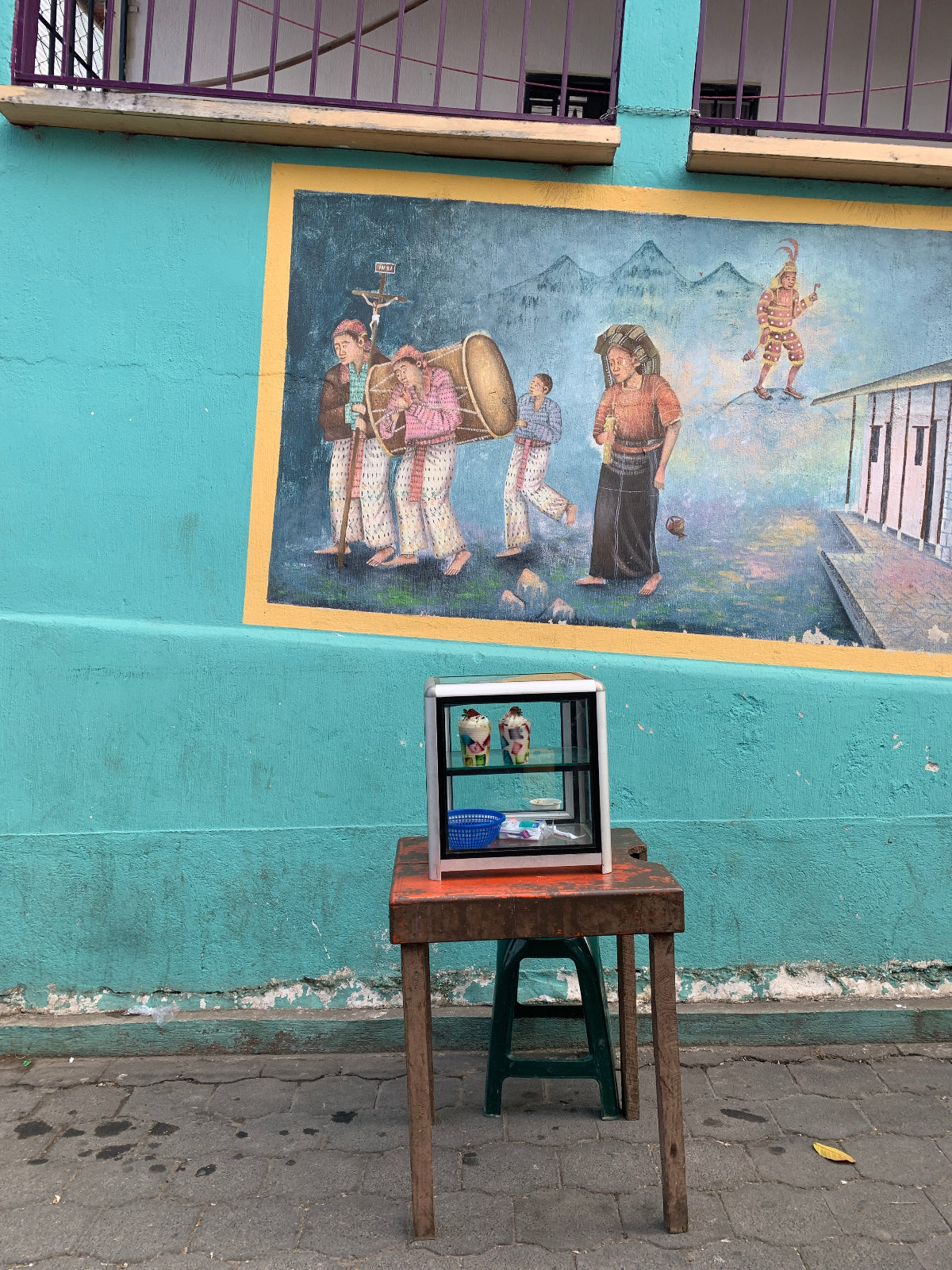 A street view of a mural and snack vendor