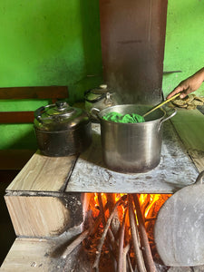 Pot containing a white cotton scarf being dyed with green dye.