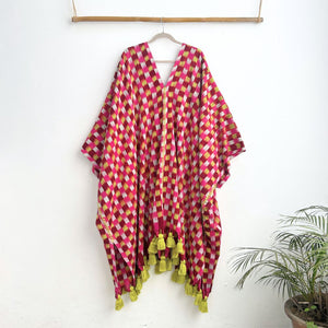 Colorful checkered garment with tassels on a white background