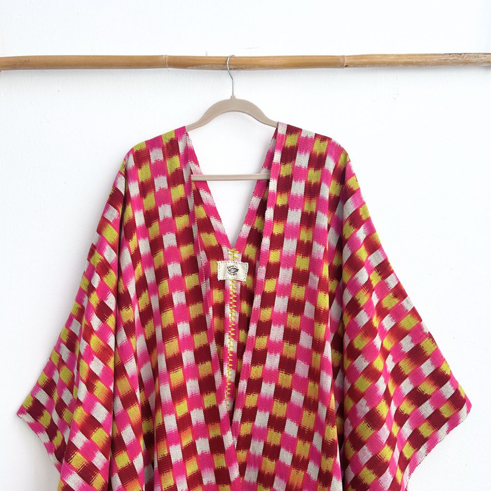 Colorful checkered garment on a hanger against a white background