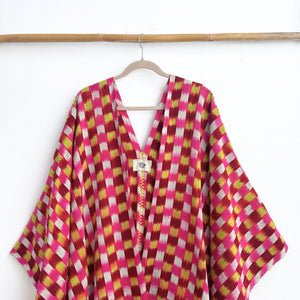 Colorful checkered garment on a hanger against a white background