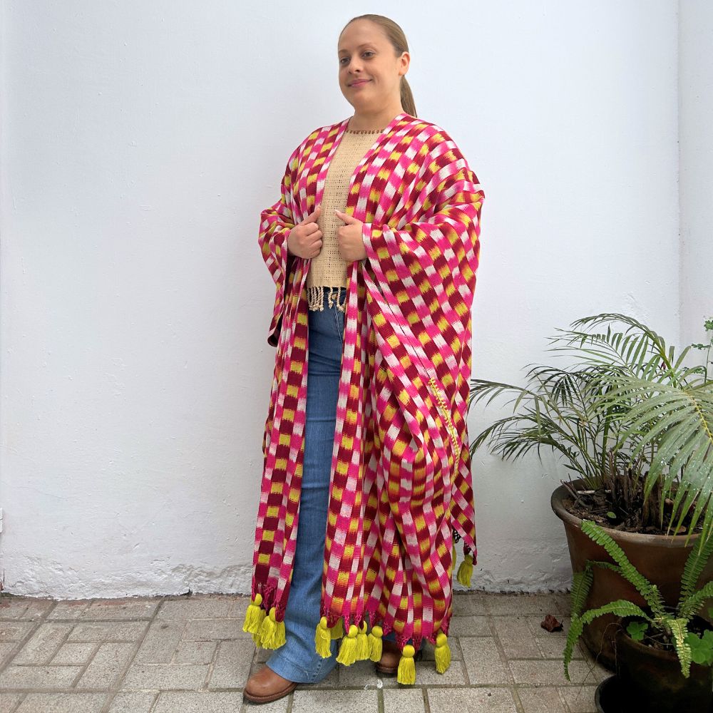 Woman wearing a colorful checkered wrap-around garment against a white background