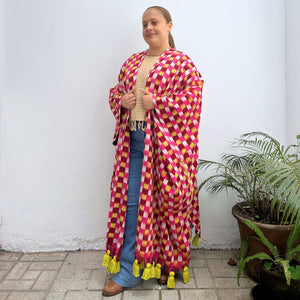 Woman wearing a colorful checkered wrap-around garment against a white background