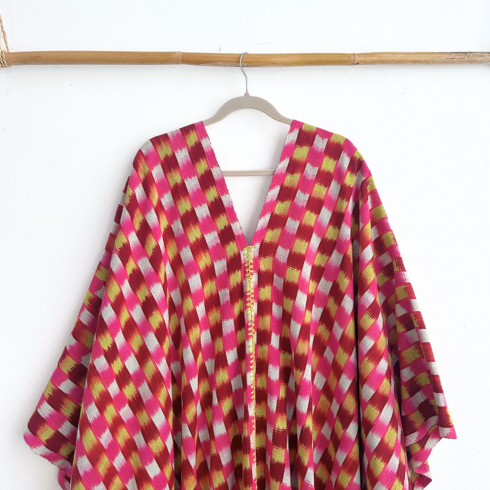 Colorful checkered garment on a hanger against a white background