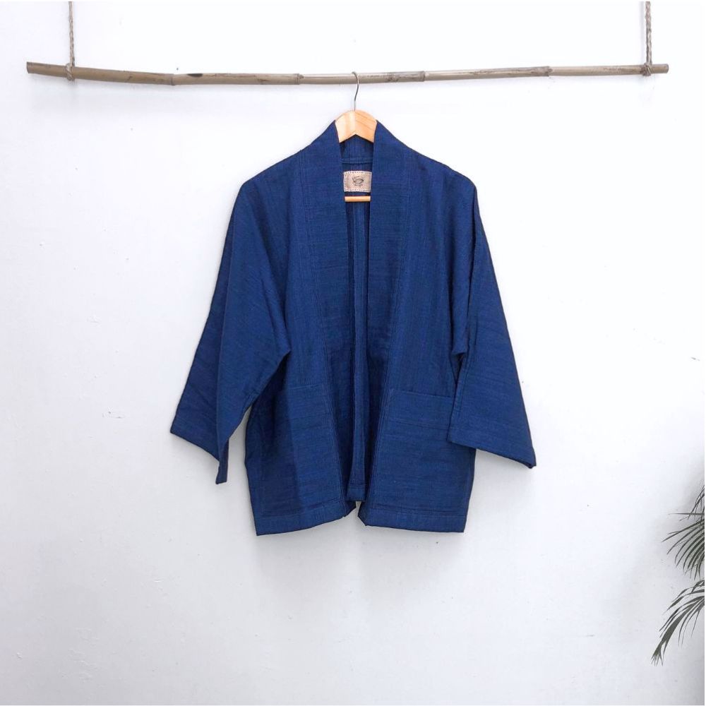 A blue jacket in front of a withe wall