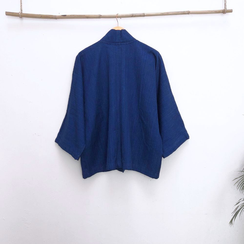 back of a blue jacket infront of a withe wall