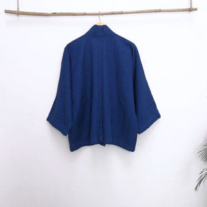 back of a blue jacket infront of a withe wall