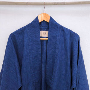 Neck of a blue jacket in front of a withe wall