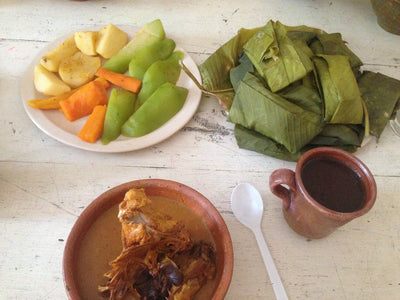 A complete, traditional meal - chicken stew, tamales, vegetables, and hot cacao