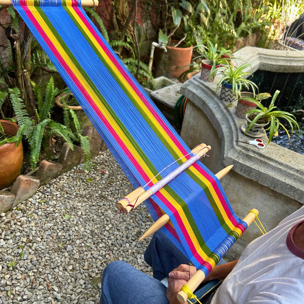 A colorful backstrap loom prepared by a student and ready to begin weaving.