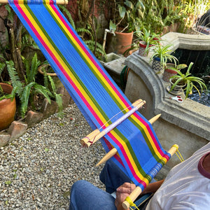 A colorful backstrap loom prepared by a student and ready to begin weaving.