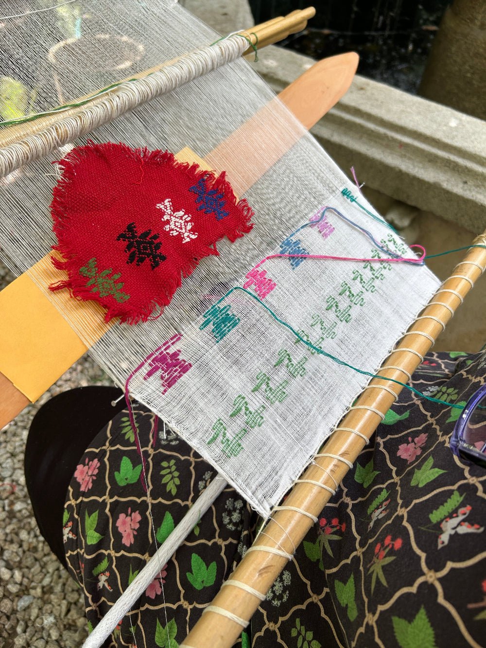 Loom in progress by the student, showing colorful brocade patterns in pikbil