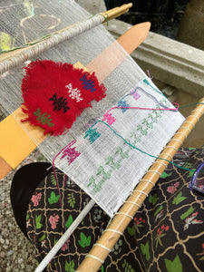 Loom in progress by the student, showing colorful brocade patterns in pikbil