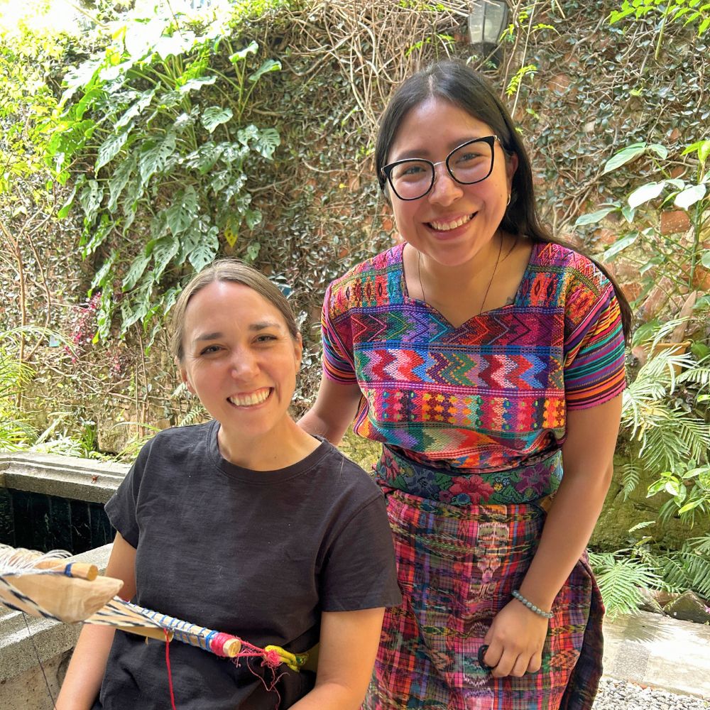 The teacher and her student smiling during the weaving class.