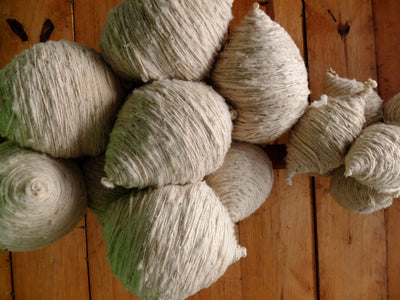 Balls of natural wool yarn on a wooden surface