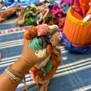 Close up of naturally dyed threads before beginning the pompom-making process.