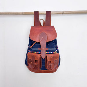 Backpack with brown leather straps and blue corte with colorful randa body on a white background
